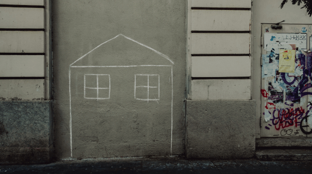 House drawn with chalk on the side of a building.